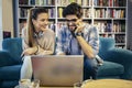 Man in eyeglasses and charming woman using laptop resting at cafe with cup of coffee Royalty Free Stock Photo