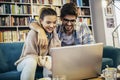 Man in eyeglasses and charming woman using laptop resting at cafe with cup of coffee Royalty Free Stock Photo