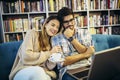 Man in eyeglasses and charming woman using laptop resting at cafe with cup of coffee Royalty Free Stock Photo