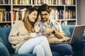 Man in eyeglasses and charming woman using laptop resting at cafe with cup of coffee Royalty Free Stock Photo