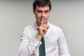 Attractive man with finger on lips and lipstick on shirt collar