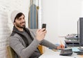 Attractive man in hipster beanie and trendy style businessman working happy at home office with desktop computer Royalty Free Stock Photo