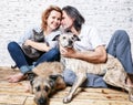 Attractive man and his young wife with pets, two dogs and a cat, a family portrait