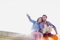 Attractive man holding map while sitting and talking to his girlfriend Royalty Free Stock Photo