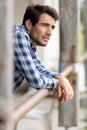 Attractive man leaning on post by barn Royalty Free Stock Photo