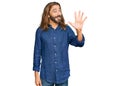 Attractive man with long hair and beard wearing casual clothes showing and pointing up with fingers number five while smiling Royalty Free Stock Photo