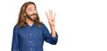 Attractive man with long hair and beard wearing casual clothes showing and pointing up with fingers number four while smiling Royalty Free Stock Photo