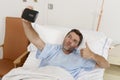 Attractive man lying on bed hospital clinic holding mobile phone taking self portrait selfie photo