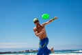 Attractive man playing frisby on beach in summer