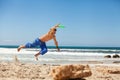 Attractive man playing frisby on beach in summer