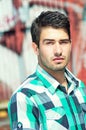 Attractive man posing outdoor over graffiti wall Royalty Free Stock Photo
