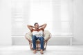 Attractive man relaxing in papasan chair near window Royalty Free Stock Photo