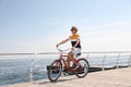 Attractive man riding bike near sea