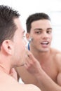 Attractive man shaving in front of bathroom mirror Royalty Free Stock Photo