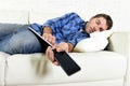 Attractive man sleeping at home couch with mobile phone and digital tablet pad in his hands Royalty Free Stock Photo