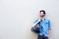 Attractive man smiling and holding travel bag over shoulder Royalty Free Stock Photo