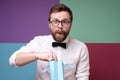 Attractive man is surprised by an unexpected surprise, he takes a gift from a package with a genuinely joyful expression