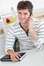 Attractive man talking on phone holding his laptop Royalty Free Stock Photo