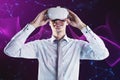 Attractive man with VR glasses on creative glowing purple metaverse space background. Abstract world and innovation concept Royalty Free Stock Photo