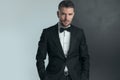 Attractive man wearing elegant tuxedo with bowtie and posing Royalty Free Stock Photo