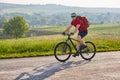 Attractive man in white helmet riding a bike on country road. Royalty Free Stock Photo