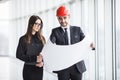 An attractive man and woman business team working construction on the building site near panoramic windows Royalty Free Stock Photo