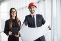 An attractive man and woman business team working construction on the building site near panoramic windows Royalty Free Stock Photo
