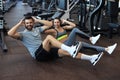 Attractive man and woman working in pairs performing sit ups in gym