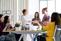 Attractive mature asian woman shaking hand with young beard hipster caucasian with welcome new employee