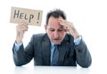 Attractive mature businessman overwhelmed and tired holding a help sign Royalty Free Stock Photo