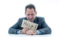 Attractive mature businessman overwhelmed and tired holding a help sign Royalty Free Stock Photo