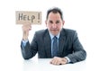 Attractive mature businessman overwhelmed and tired holding a help sign Royalty Free Stock Photo