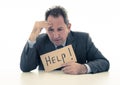 Attractive mature businessman overwhelmed and tired holding a help sign Royalty Free Stock Photo