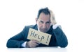 Attractive mature businessman overwhelmed and tired holding a help sign Royalty Free Stock Photo