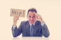 Attractive mature businessman overwhelmed and tired holding a help sign Royalty Free Stock Photo