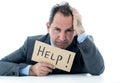 Attractive mature businessman overwhelmed and tired holding a help sign Royalty Free Stock Photo