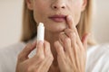 Attractive mature woman applying lipstick and touching lips, moisturizing skin, closeup shot, cropped Royalty Free Stock Photo