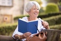 attractive mature woman reading book in park Royalty Free Stock Photo