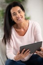 attractive mature woman reading book on tablet computer Royalty Free Stock Photo