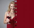 Attractive mature woman in red evening dress with glass of red wine. Copy space Royalty Free Stock Photo