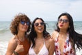 Attractive mature woman next to two young, pretty, brunette South American women in bikinis and sunglasses taking funny pictures Royalty Free Stock Photo