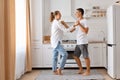 Attractive man and beautiful young woman having fun together in the kitchen, romantic couple is dancing and expressing love, being Royalty Free Stock Photo