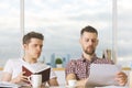 Attractive men reading book and doing paperwork Royalty Free Stock Photo