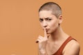 Attractive mid 30s woman pressing finger to lips as if asking to keep silent. Photo of young angry woman making Shhh gesture. Royalty Free Stock Photo