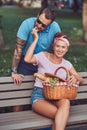 Attractive middle age couple during dating, enjoying a picnic on a bench in the city park. Royalty Free Stock Photo