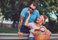 Attractive middle age couple during dating, enjoying a picnic on a bench in the city park. Royalty Free Stock Photo