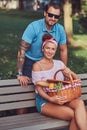 Attractive middle age couple during dating, enjoying a picnic on a bench in the city park. Royalty Free Stock Photo