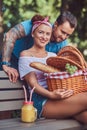 Attractive middle age couple during dating, enjoying a picnic on a bench in the city park. Royalty Free Stock Photo