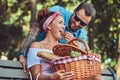 Attractive middle age couple during dating, enjoying a picnic on a bench in the city park. Royalty Free Stock Photo