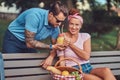 Attractive middle age couple during dating, enjoying a picnic on a bench in the city park. Royalty Free Stock Photo